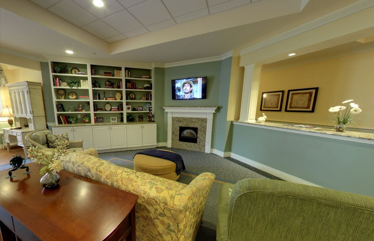 A cozy living room with a fireplace, television, and bookshelves.