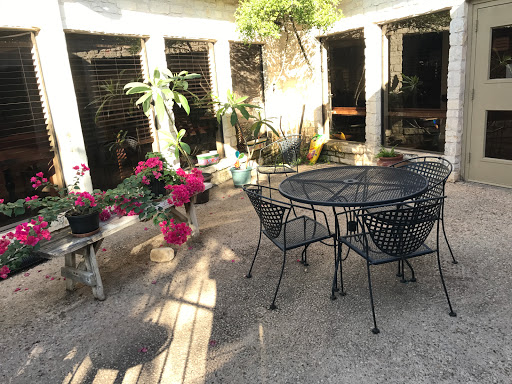 A serene outdoor patio adorned with plants and a cozy table setting.