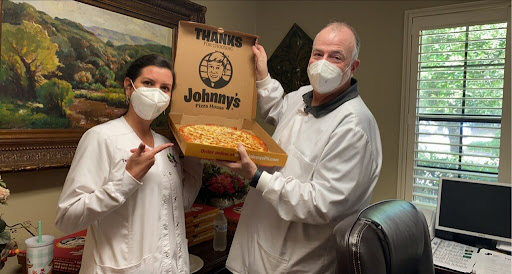 Sharing a delicious pizza from Johnny's with smiles and masks!
