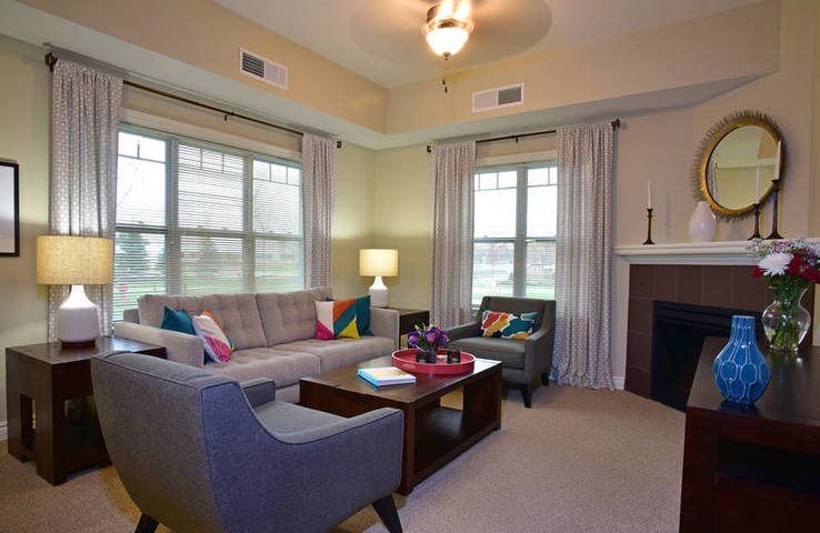A cozy living room with a modern design featuring a sofa, armchairs, and a fireplace.