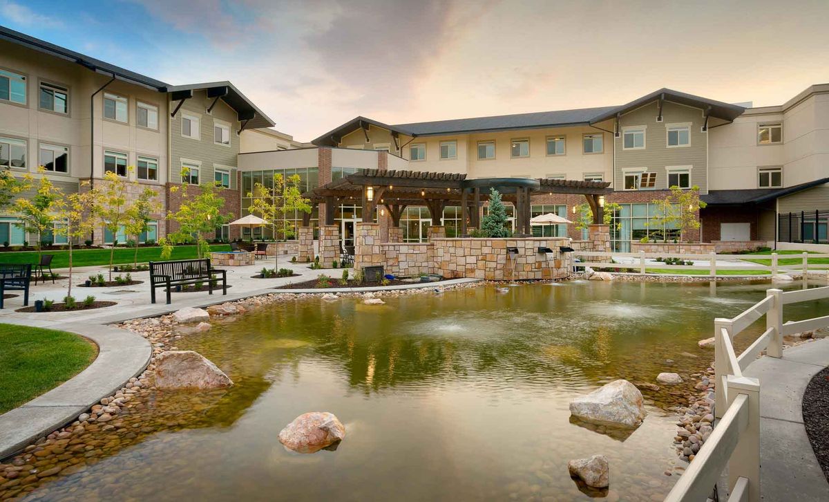 A picturesque building with a reflective pond in the foreground, set against a tranquil outdoor landscape.