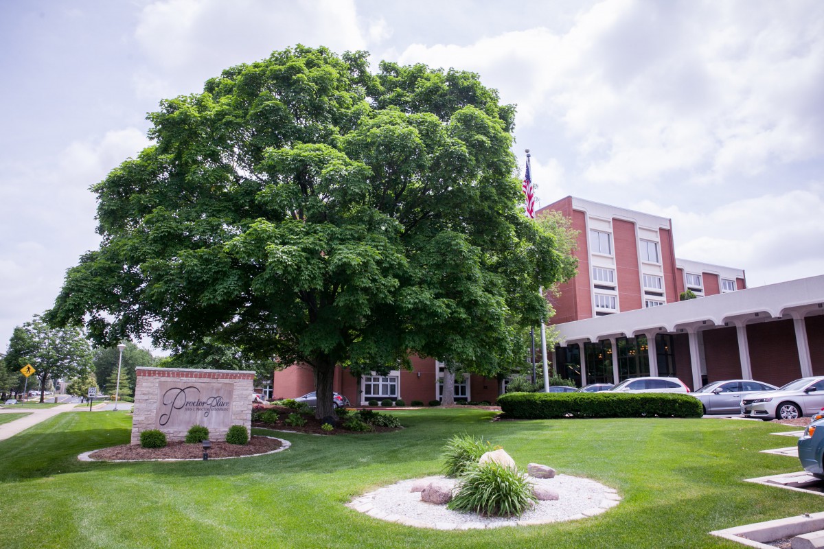 A building surrounded by lush greenery and a large tree.