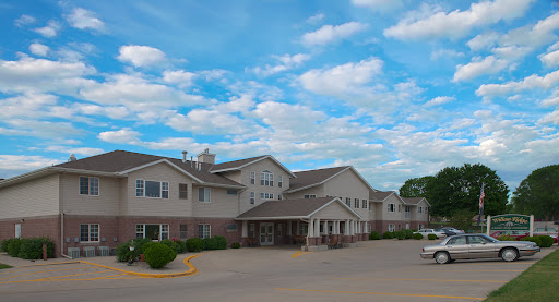 A pleasant residential building under a bright blue sky with fluffy clouds.