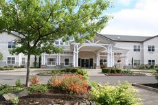 A view of a building entrance surrounded by landscaped greenery.