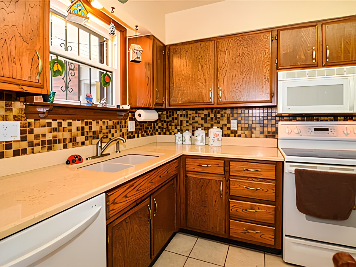 A cozy kitchen featuring wooden cabinets, a tiled backsplash, and a range of appliances.