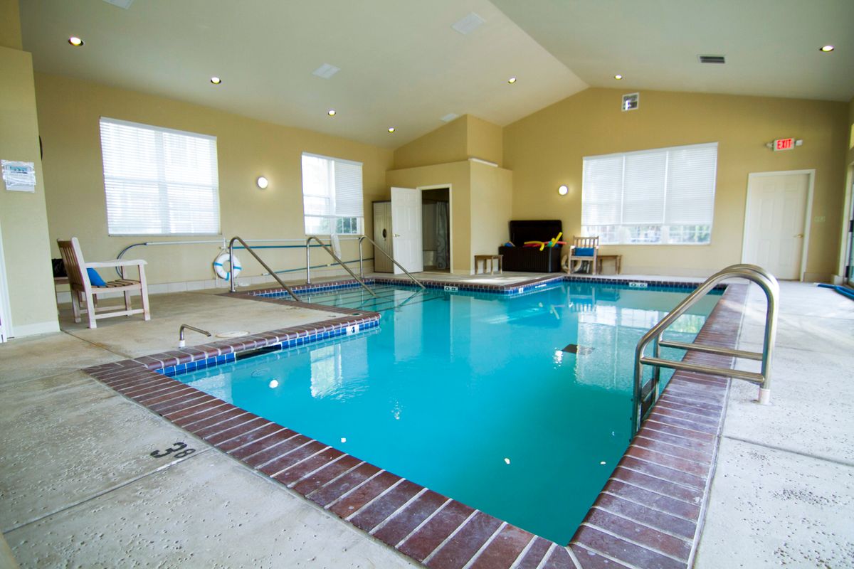 An indoor swimming pool with accessible features and seating area.