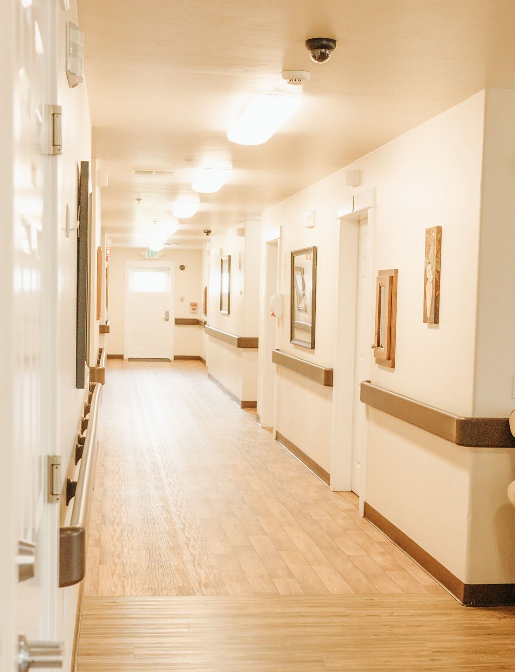 A brightly lit and empty hospital hallway with multiple doorways.