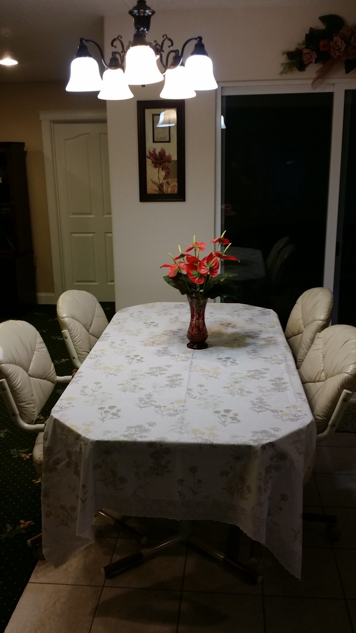 A dining table with a floral centerpiece in a well-lit room.