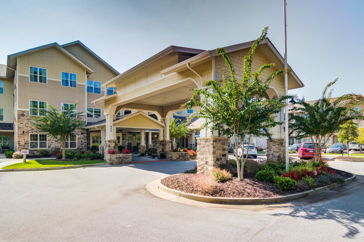 A well-maintained building entrance surrounded by landscaping.