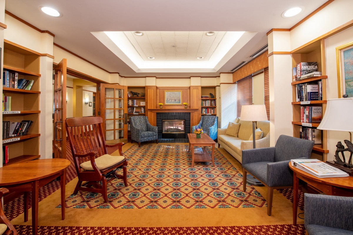 A cozy living room with a fireplace, comfortable seating, and warm lighting.