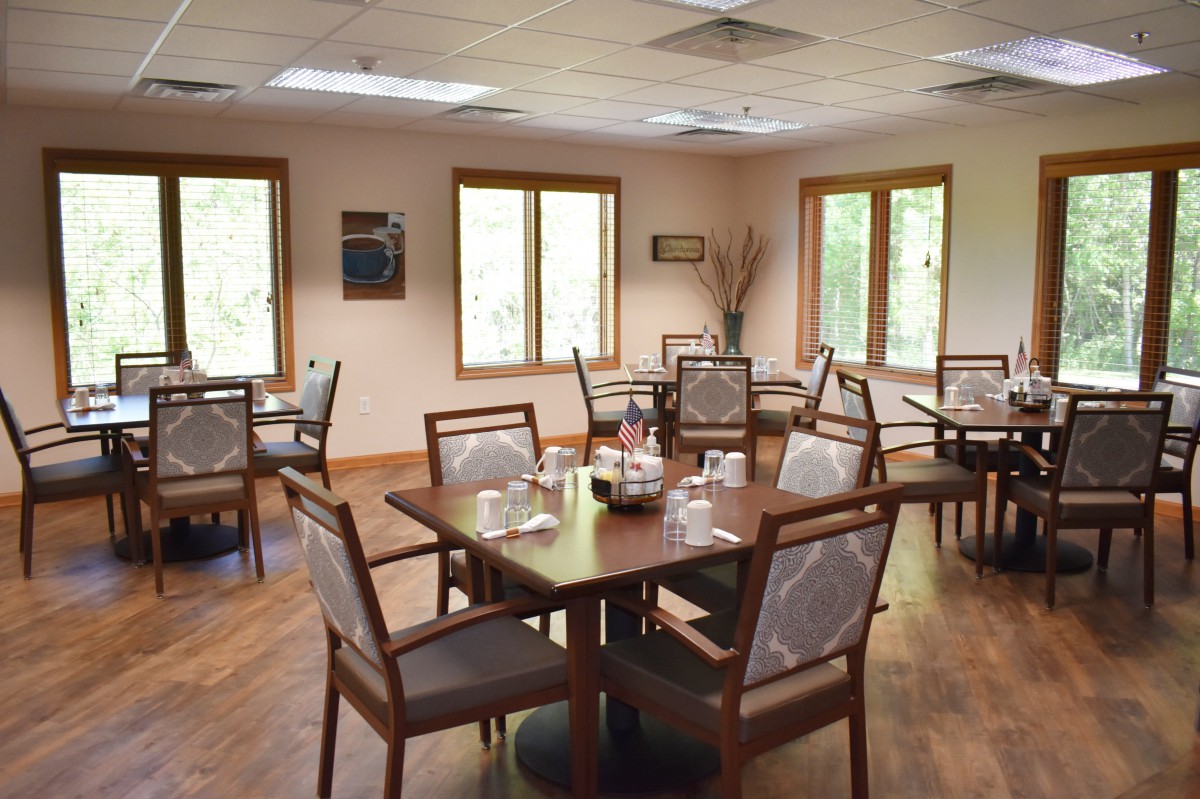 An empty dining room with neatly arranged tables and chairs.