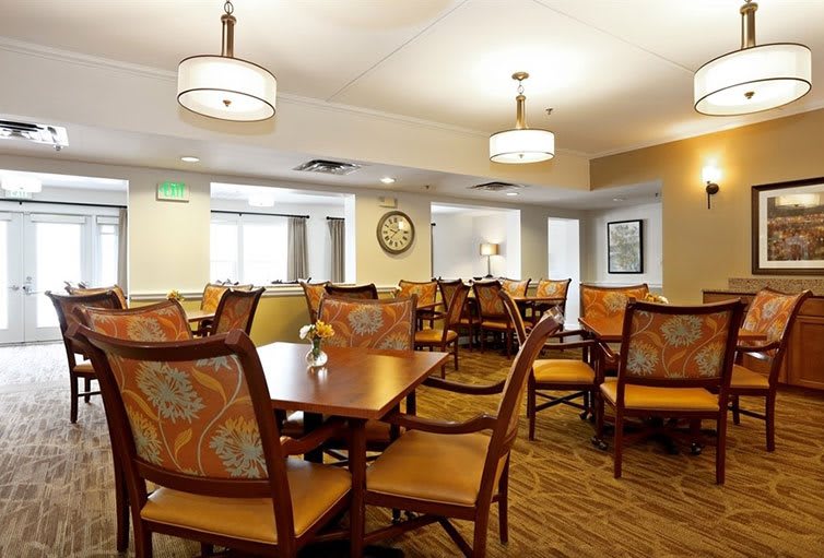 A well-lit dining area featuring multiple tables and chairs in a cozy setting.
