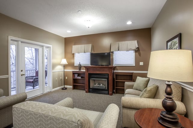 A cozy living room featuring a fireplace, television, and comfortable seating.
