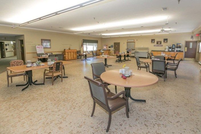 An empty dining room with several tables and chairs arranged neatly.
