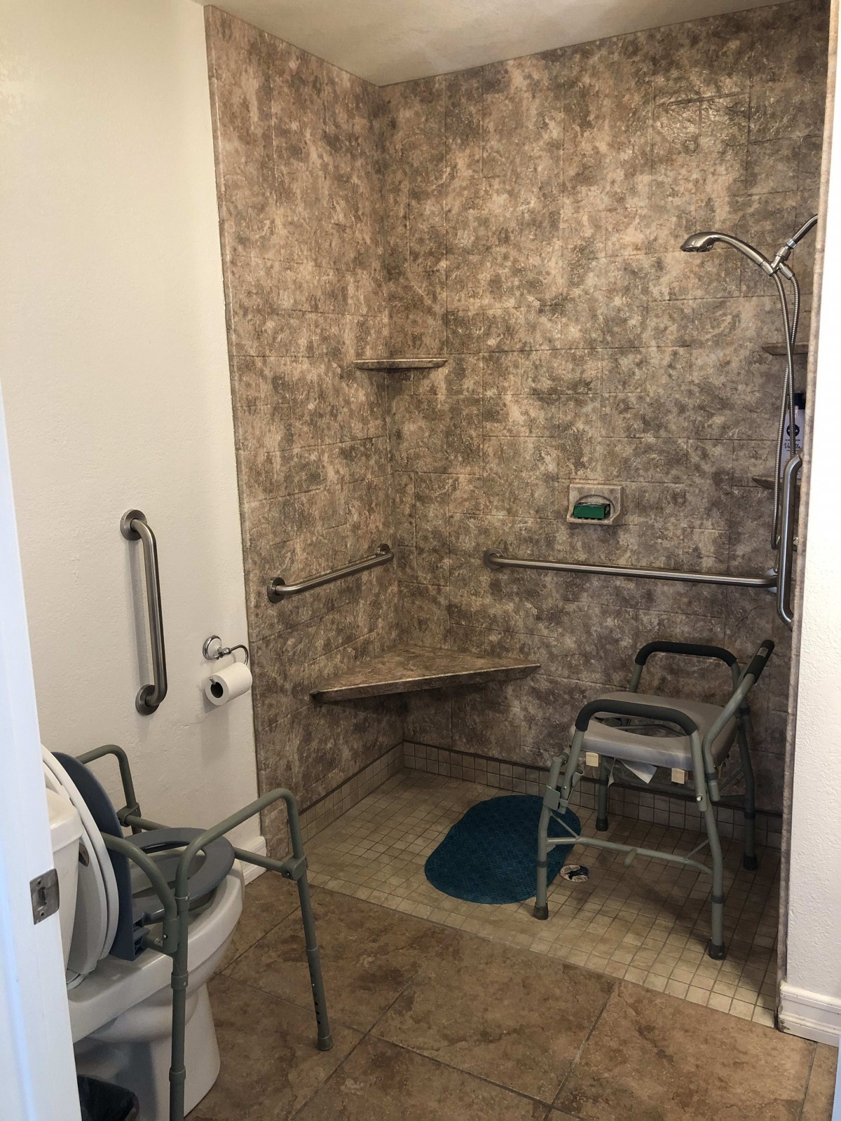 An accessible bathroom featuring a shower area with grab bars and a shower chair for mobility support.