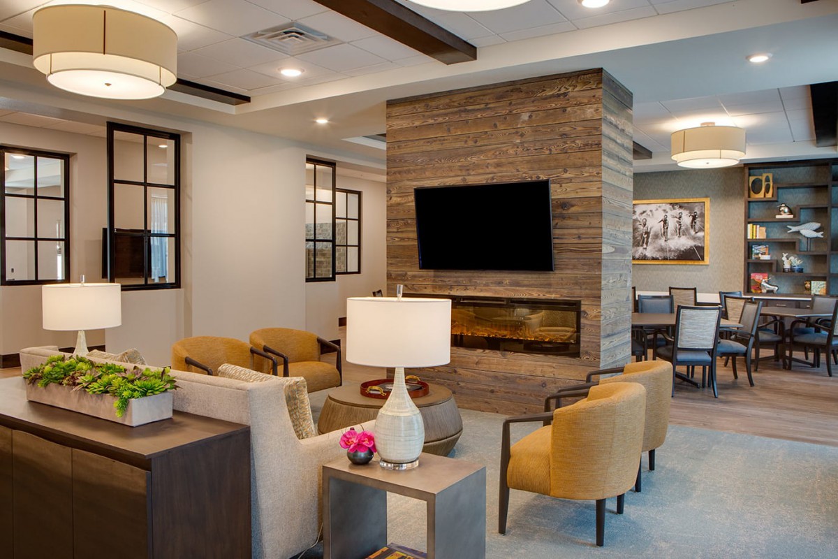 A modern living room with a cozy seating area, fireplace, and television.