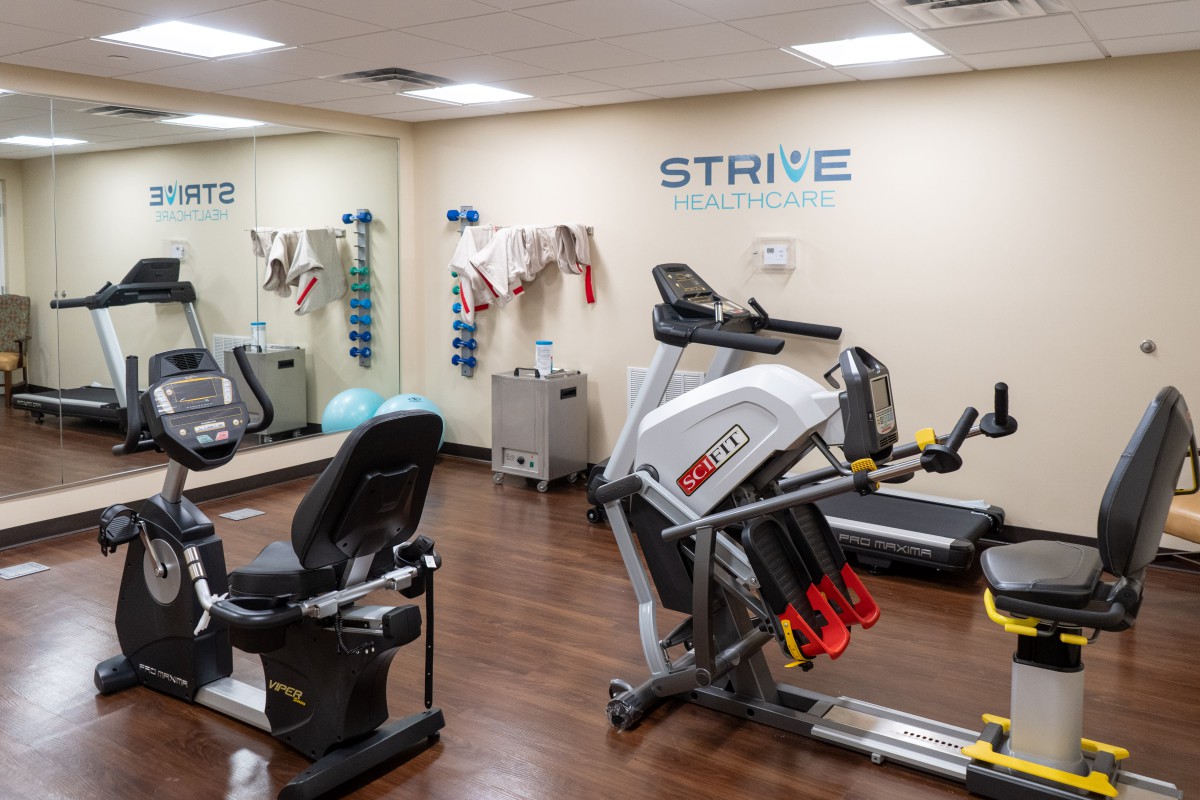 A well-equipped fitness center featuring a treadmill and stationary bike.