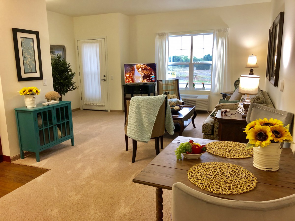 A cozy living room with comfortable furniture, a television, and a dining area.
