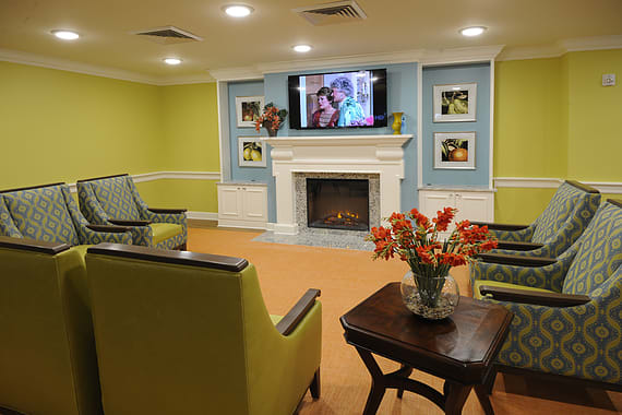 A cozy living room with modern decor, featuring a fireplace, television, and comfortable seating.
