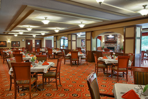 A cozy dining area featuring elegantly set tables and warm lighting.