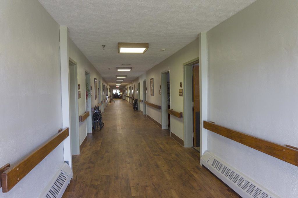 A long corridor inside a building, likely a hospital or healthcare facility.