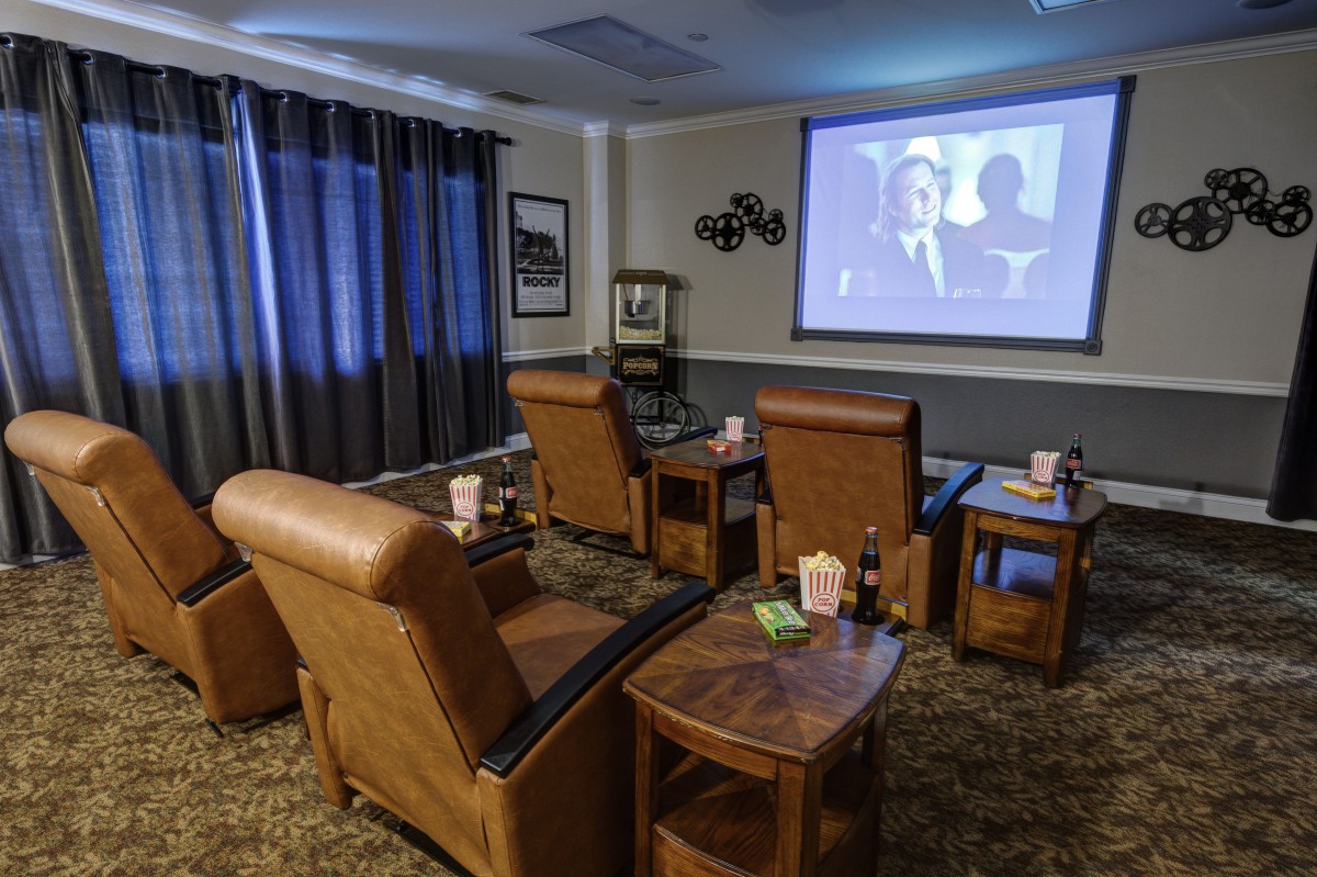 A cozy home theater setup with recliner chairs facing a projector screen.
