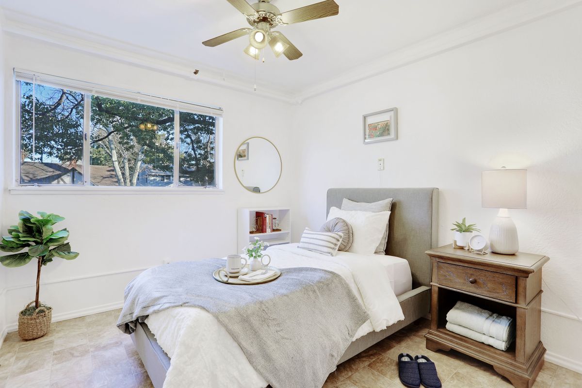 A cozy minimalist bedroom with a single bed, nightstand, and decorative elements.