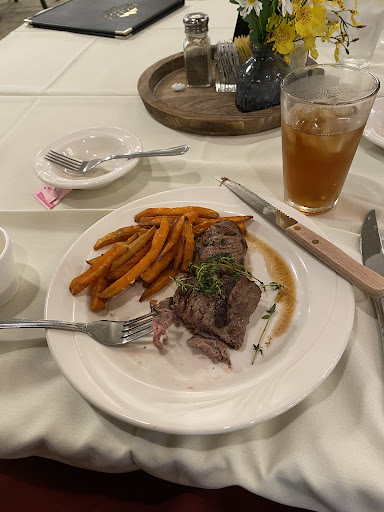 A delicious plate of beef with sweet potato fries and iced tea.