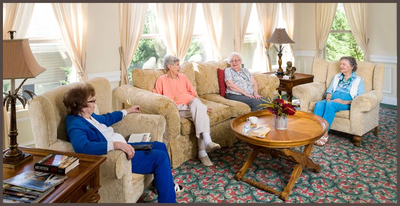 A group of seniors enjoying a conversation in a cozy living room setting.