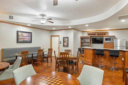 A cozy and inviting dining area featuring wooden furniture, a ceiling fan, and a bar, perfect for gatherings and leisure activities.