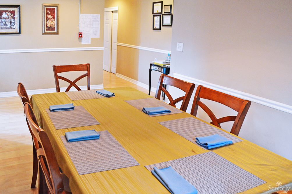 A neatly set dining table with placemats and napkins in a cozy dining room.