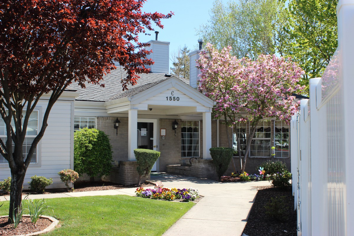 A charming house with a well-maintained garden and blooming trees.