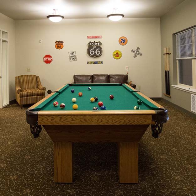 A cozy recreational room featuring a pool table and Route 66 themed decor.