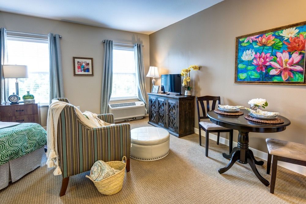 A cozy living room with comfortable seating, a table, and artwork on the walls.