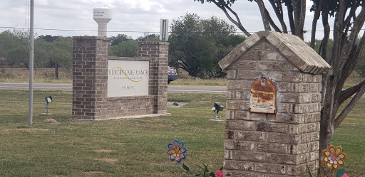 The entrance sign of a neighborhood, showcasing well-maintained landscaping and a decorative touch.