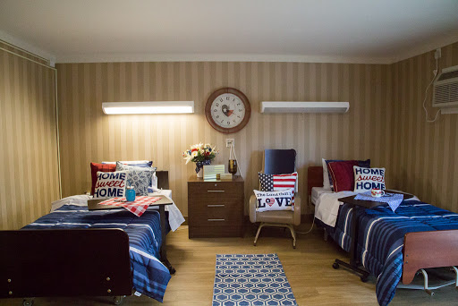 A cozy shared bedroom with two beds, decorated with patterned pillows and a warm ambiance.