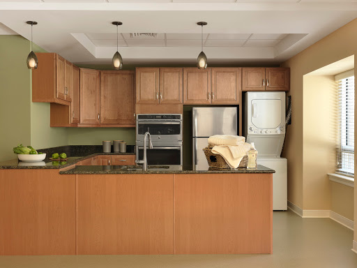 A modern kitchen featuring wooden cabinetry, sleek appliances, and a spacious layout.