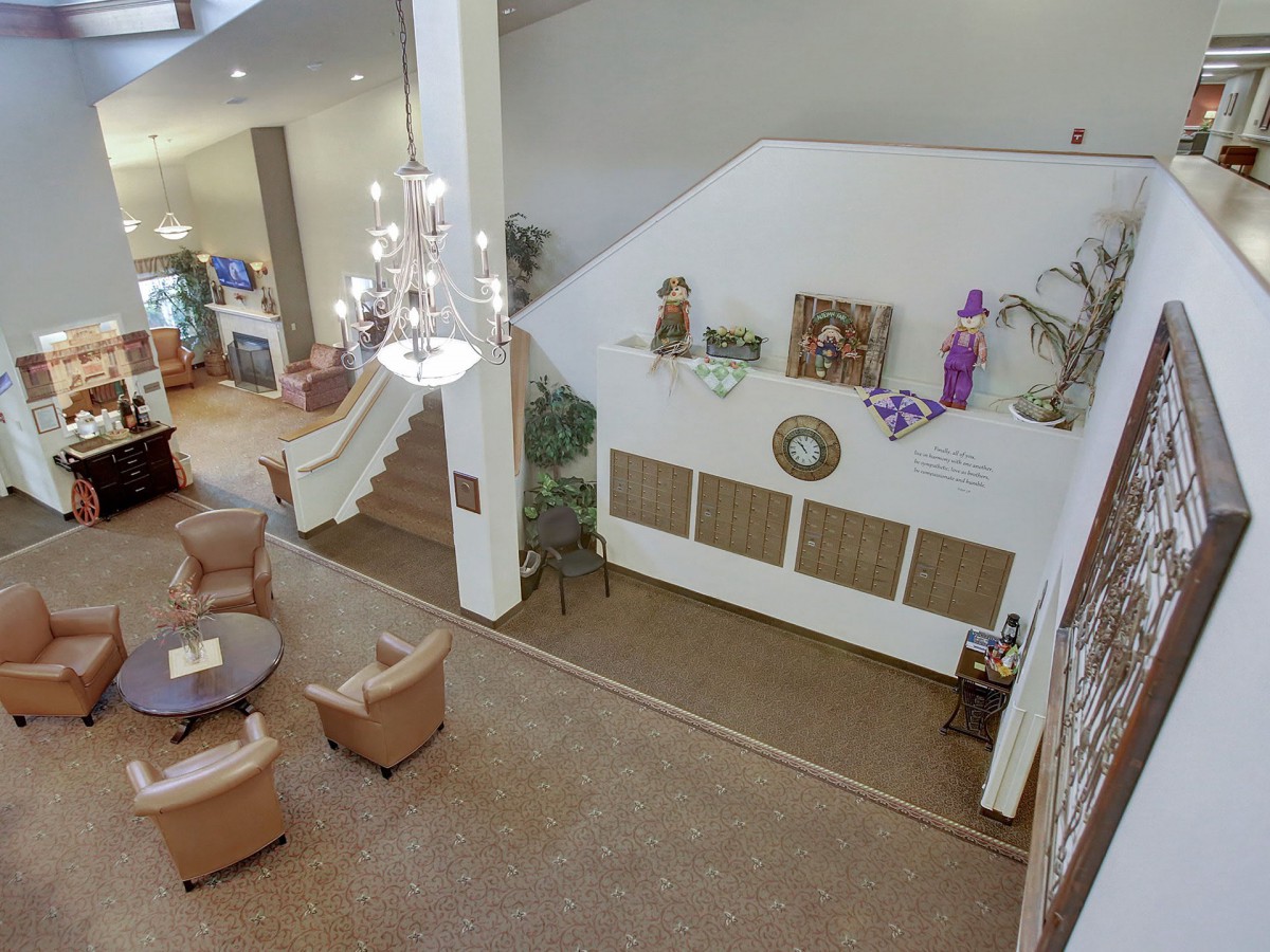 A spacious lobby featuring a seating area, elegant chandelier, and decorative elements.