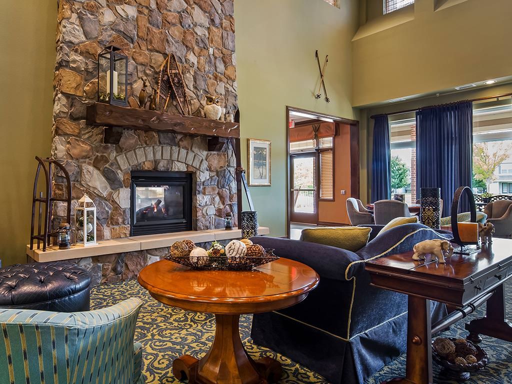 A cozy living room with a stone fireplace and stylish furniture.