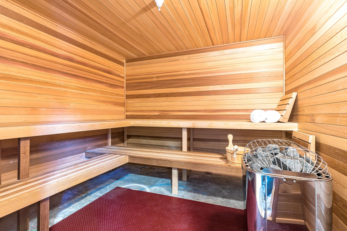 A cozy wooden sauna with benches and a heater.