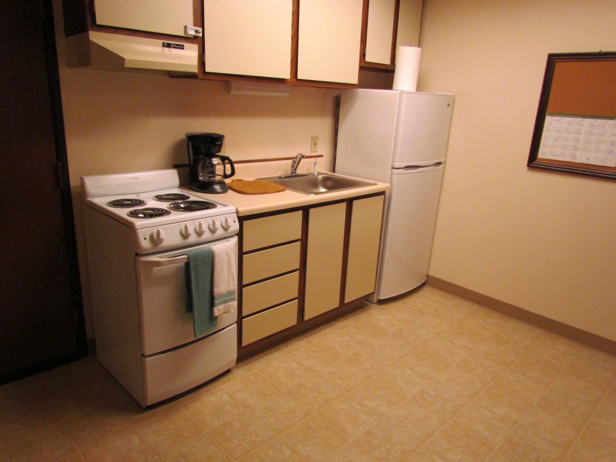 A small, minimalist kitchen with basic appliances and cabinetry.