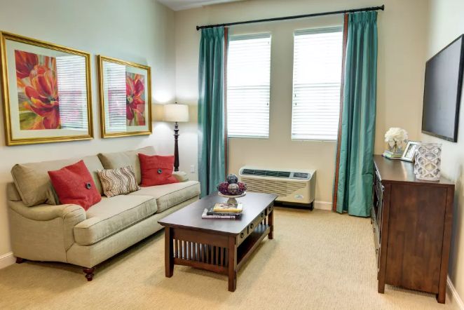 A cozy living room with a sofa, coffee table, and decorative artwork.