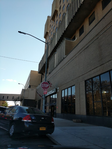 A view of a modern building with large windows and a stop sign on a city street.