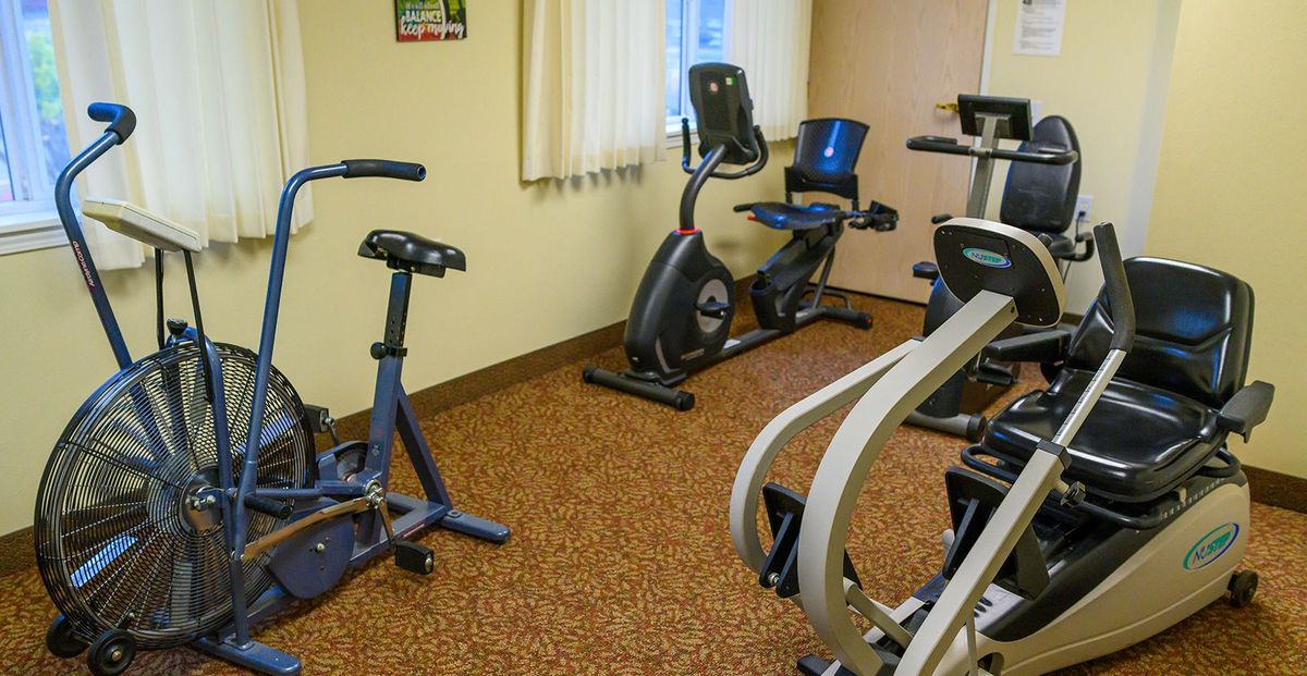 A small indoor gym with several stationary bikes and exercise machines.