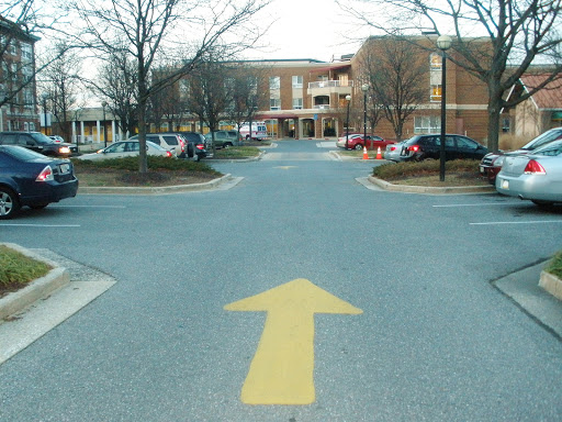 A view of a parking lot with a clear directional arrow pointing straight ahead.