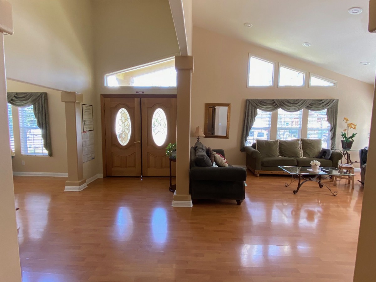 Spacious living room with wooden floors and large windows.