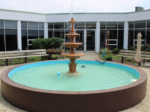 A beautiful fountain surrounded by benches in a serene courtyard.