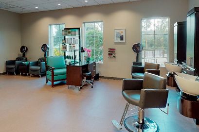 A well-lit salon interior with chairs, mirrors, and hair dryers neatly arranged.