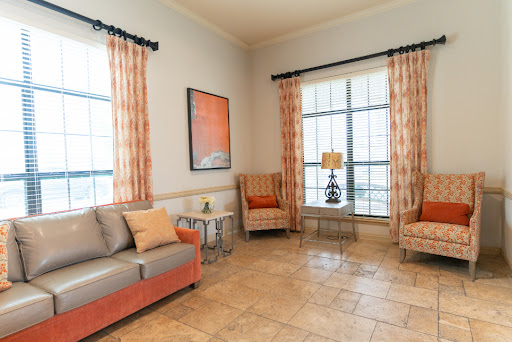 A cozy living room featuring a comfortable sofa and armchairs, adorned with stylish curtains and decorative artwork.
