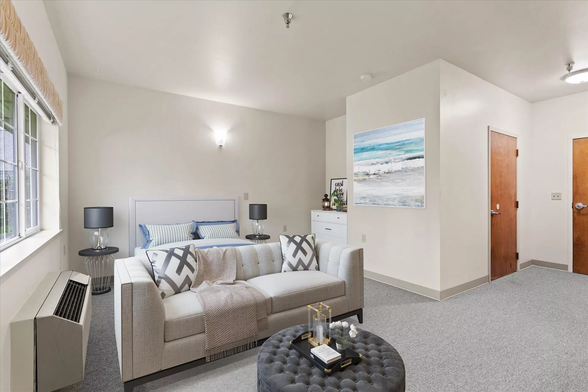 A modern living space with a combined bedroom area, featuring neutral tones and stylish decor.